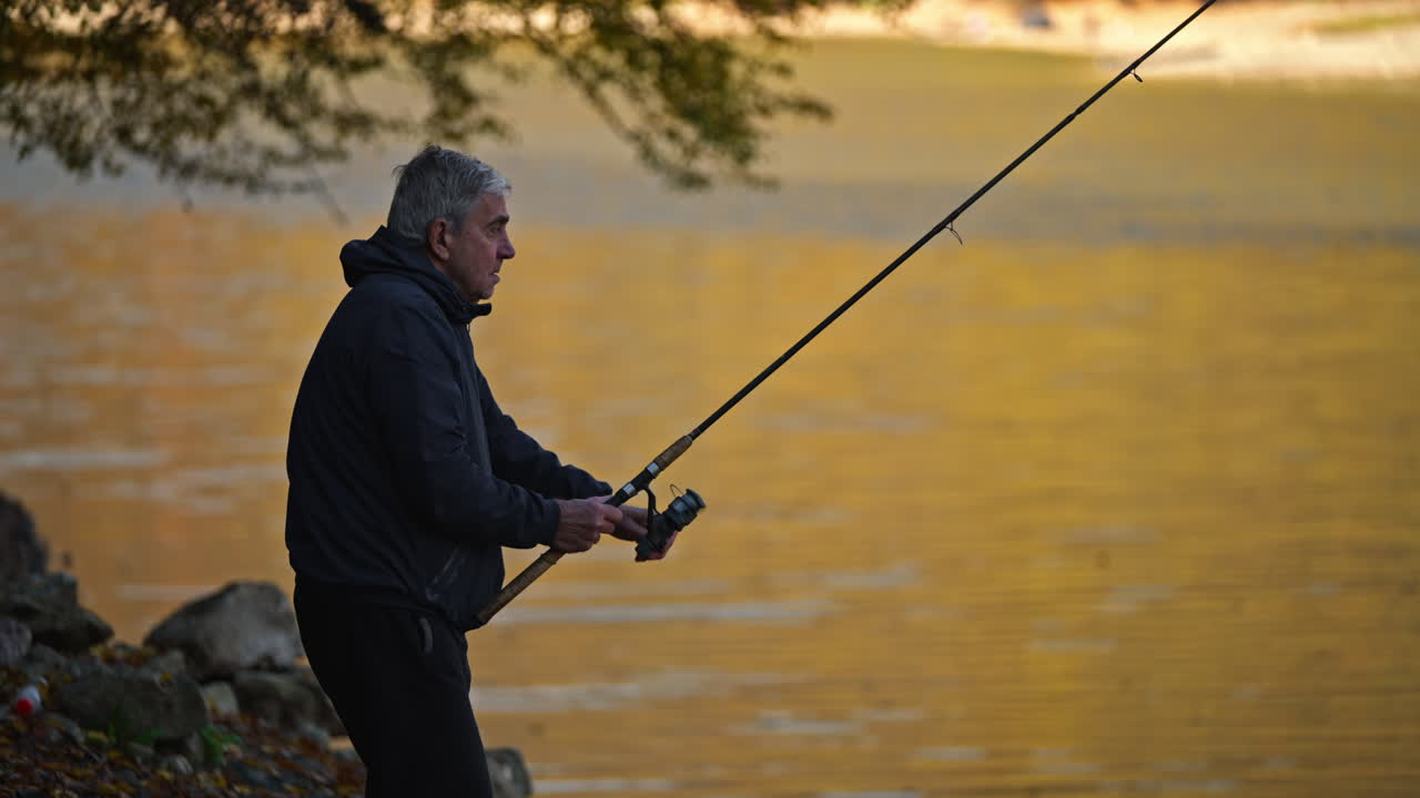 Pria memancing di tepi danau