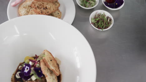 prepared and decorated meal on white plate in kitchen, slow motion