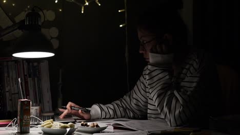 a student scrolling laptop studying at night