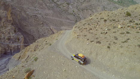 Drohnenaufnahme-Eines-Safari-Jeeps,-Der-Durch-Einsame-Hügel-Von-Mustang-Nepal-Fährt