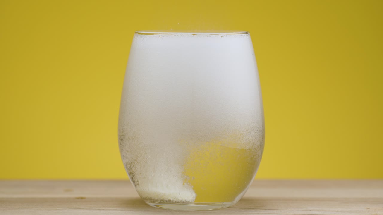 Magnesium fizzy tablet drops in clear water and dissolves in real time