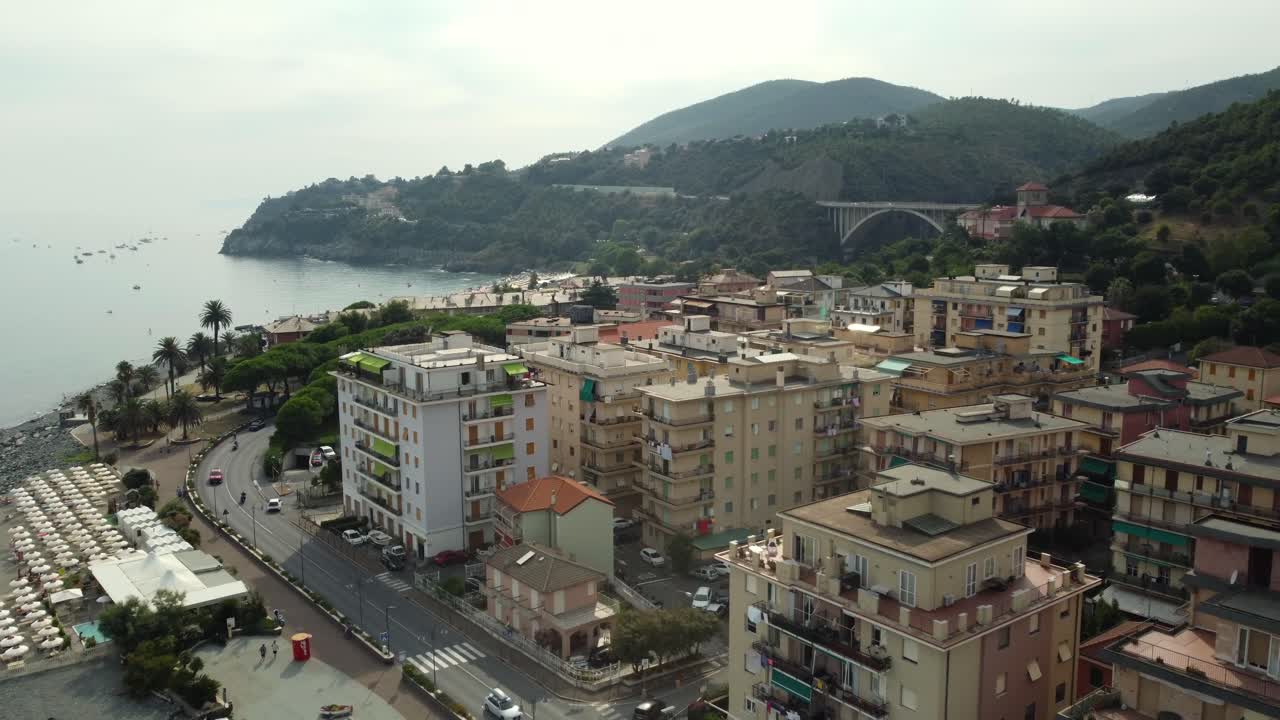 Aerial view of a coastal town with a bridge and mountains