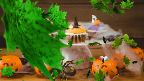 digital composite video of autumn leaves falling against halloween cupcakes in background