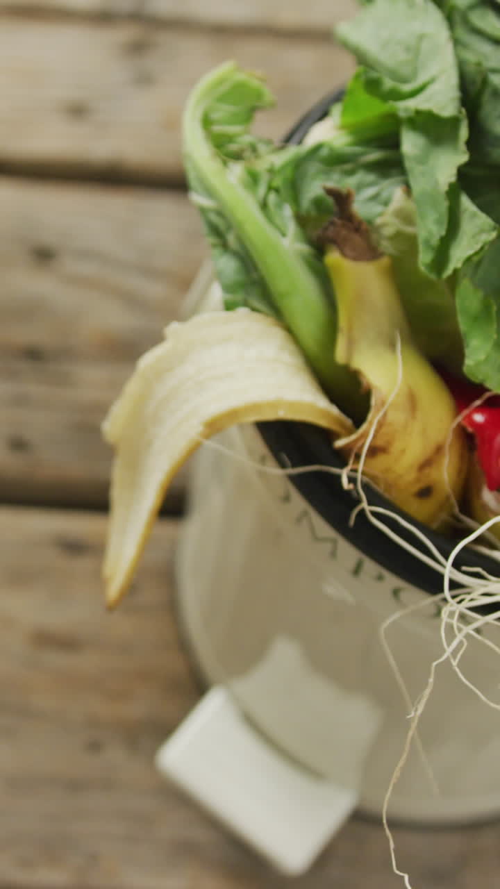 나무 바탕에 유기 폐기물과 복사 공간이 있는 색 비료통의 비디오