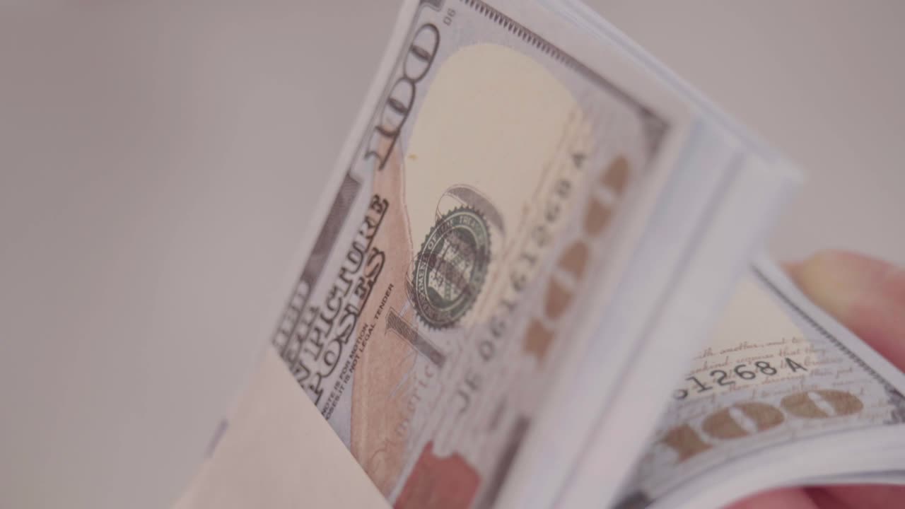 Mani maschili che contano una pila di nuove banconote da cento dollari USA. Un uomo d'affari sta contando denaro contante. Il concetto di investimento, cambio di denaro, tangenti o corruzione.