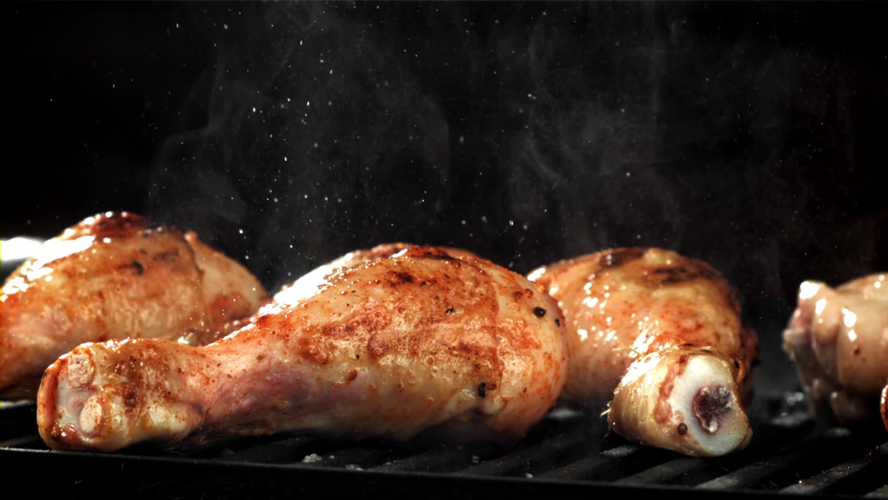 Deliziosi fusi di pollo che sfrigolano su una griglia calda