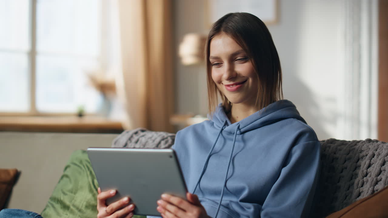 mujer usando una tableta en un sofá