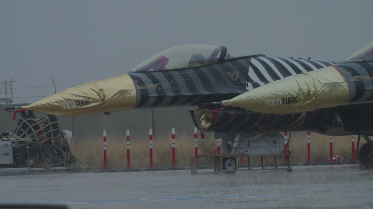 Истребитель SOLOTURK F-16, припаркованный на аэродроме под дождем