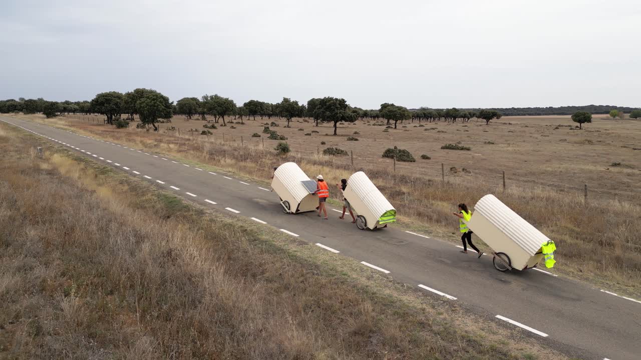 Nomad family pulling small homes on wheels in countryside in Spain