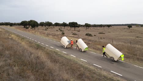 nomad family pulling small homes on wheels in countryside in spain