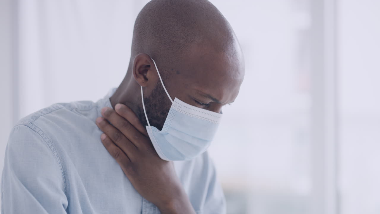 hombre negro con una máscara mientras está sentado