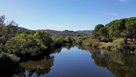 Sierra-de-Andujar-tranquil-reservoir-and-picturesque-forested-landscape-AERIAL-FLIGHT