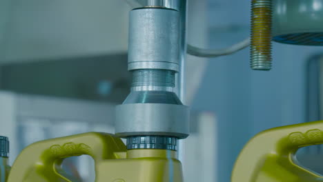 real shot of package machine at a dairy factory automatically screws caps onto glass jars of milk or yogurt