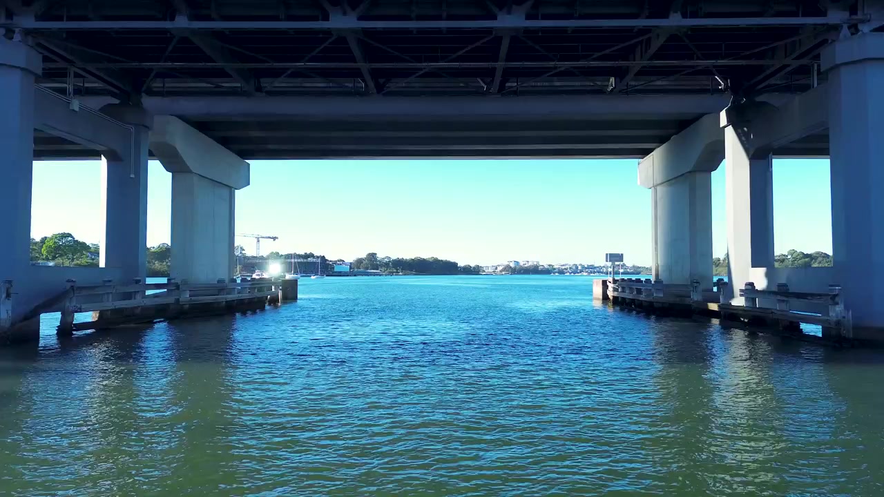 Drohnen-Luftaufnahme der Landschaft mit Autoverkehr, der die Ryde Bridge überquert, mit umliegendem Hafen am Wasser entlang des Parramatta River in Rhodes, Sydney, NSW, Australien, im Bereich Transport und Meerestourismus