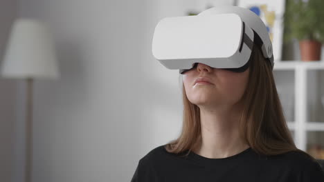 Weibliche-Benutzerin-Testet-Neues-Modell-Eines-Head-Mounted-Displays-Für-Virtual-Reality,-Mittleres-Porträt-Einer-Frau-Mit-HMD-Im-Innenbereich,-Gadget-Für-Videospiele-Und-Bildung