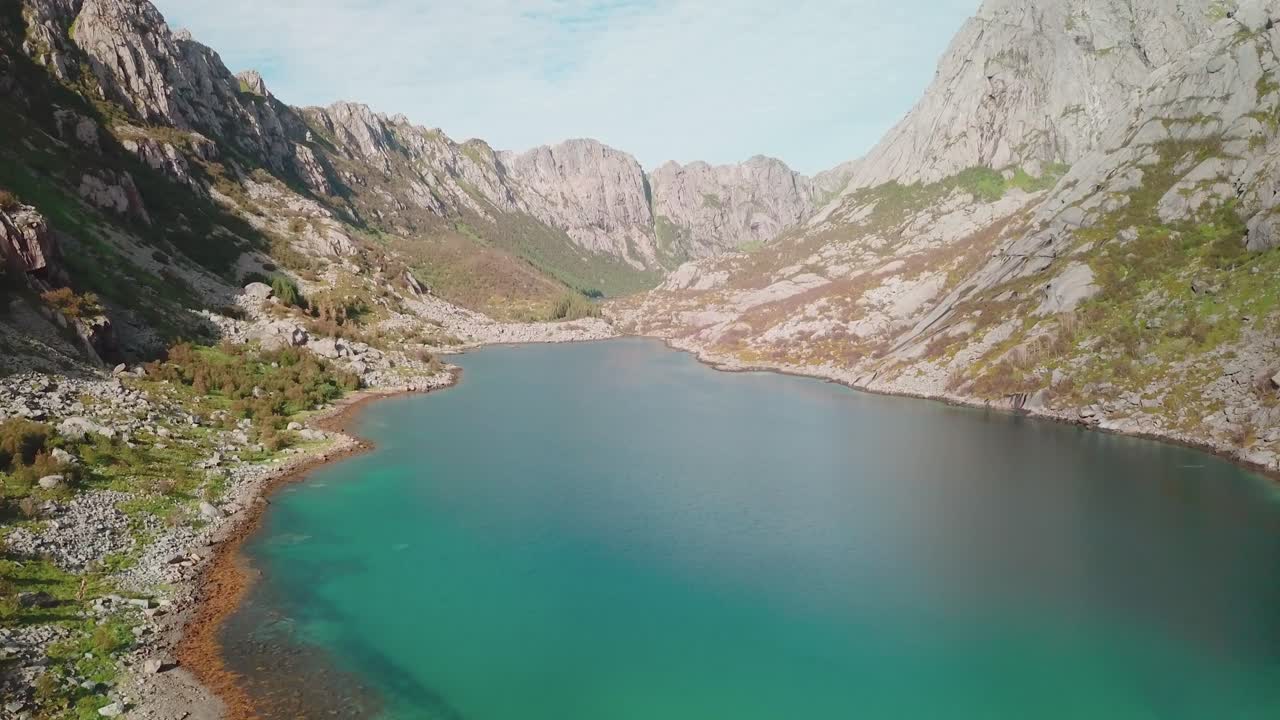 가파른 바위 절벽이 사방에 있는 바다 위의 전방 드론 샷
