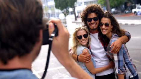 young man photographing his friends with a camera