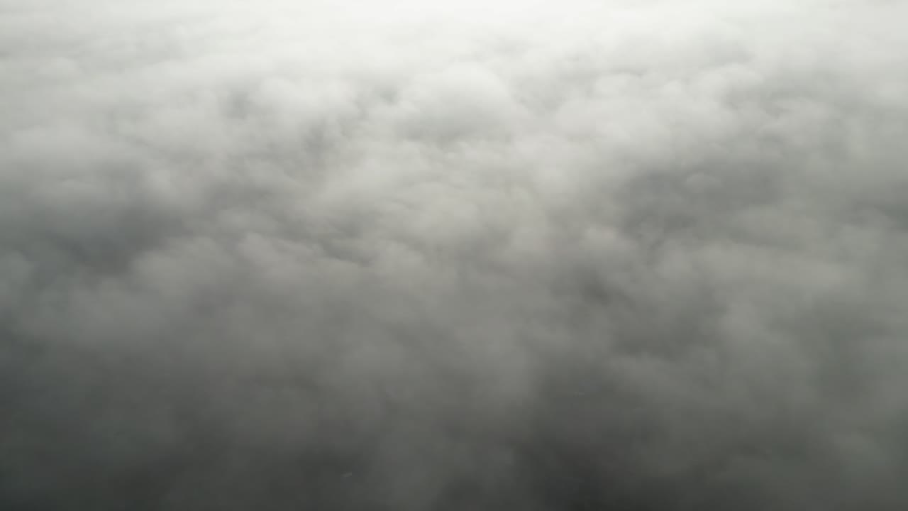 Spectacular footage from a drone looking over the top of a layer of fog