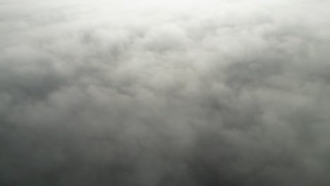 spectacular footage from a drone looking over the top of a layer of fog