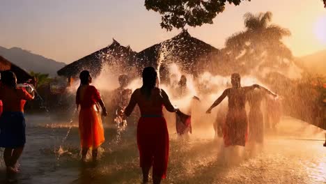 women enjoying a water splash festival at sunset