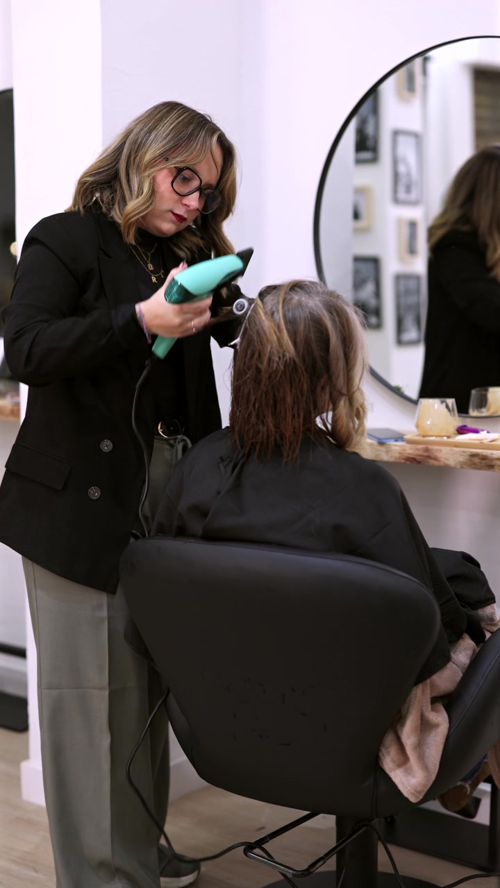 Professional Hairdresser Blow Drying Client's Hair in Modern Salon