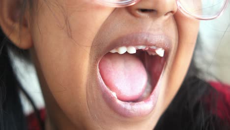 un primer plano de una joven sonriendo con la boca abierta