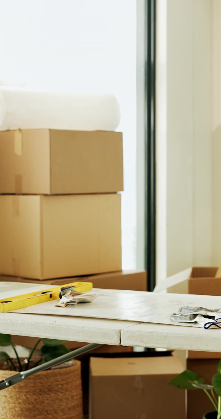 Cardboard Moving Boxes and Tools on a Table in a New Home
