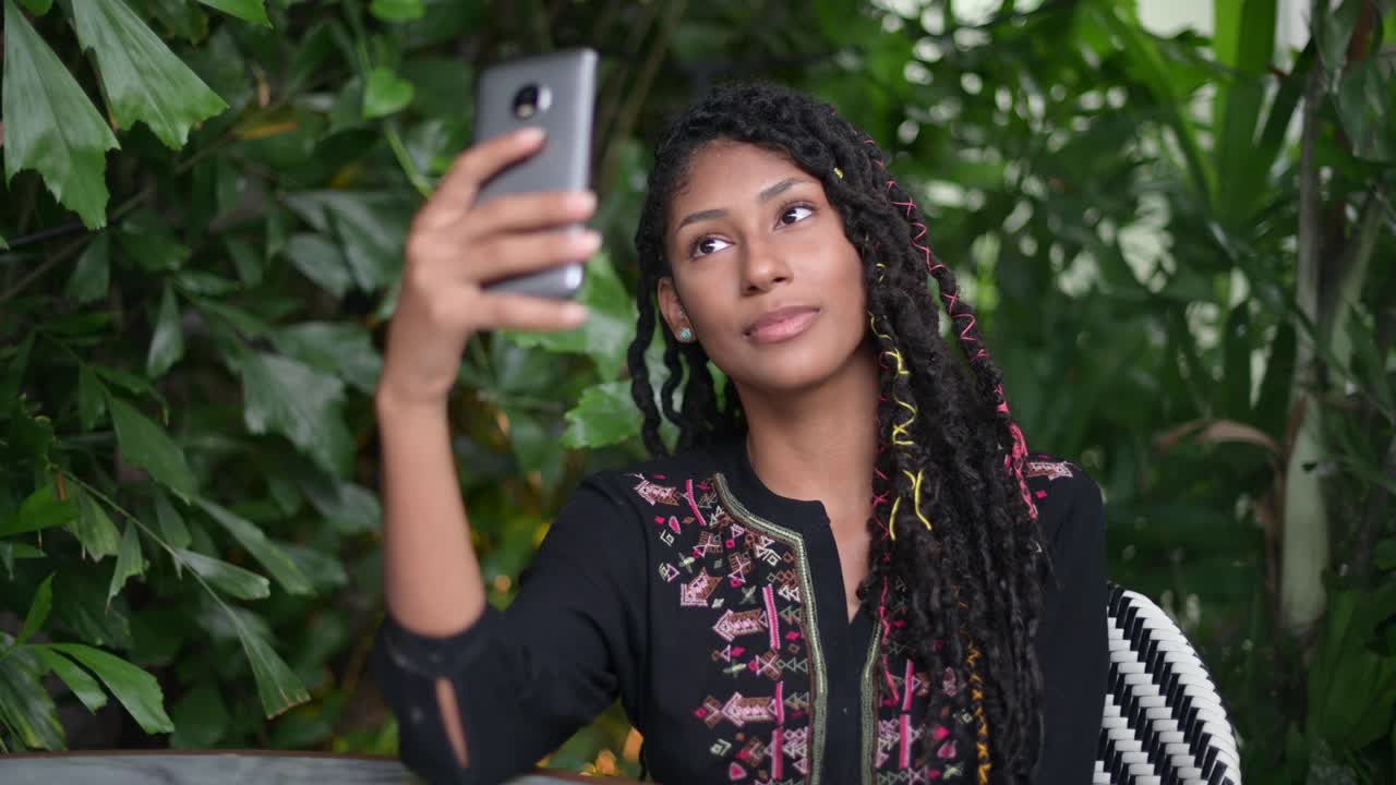 Afro latina woman taking a selfie in restaurant