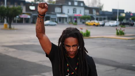 hombre afroamericano con rastas levanta el puño en apoyo del movimiento de protesta blm