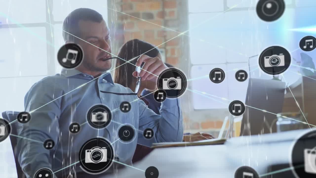 Animation of network of connections with icons over diverse business people working at office