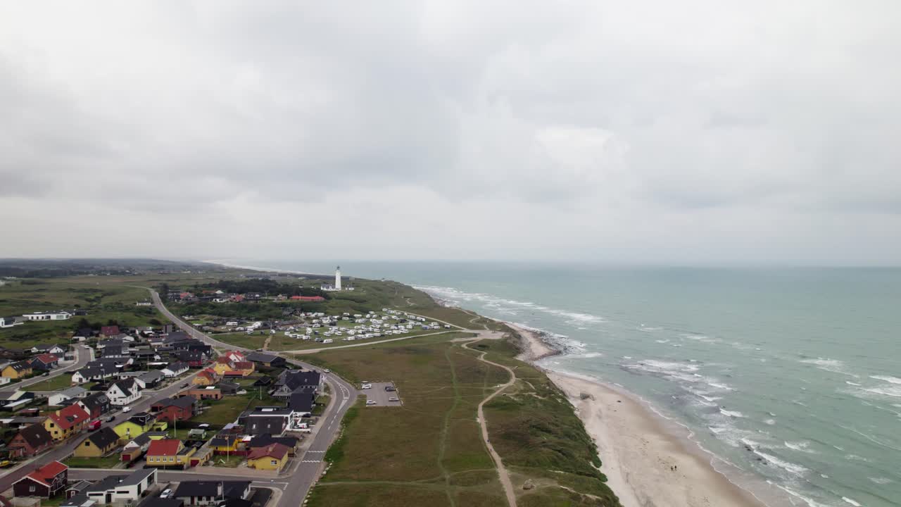 la ciudad costera en un día nublado conduce al faro de hirtshals en el borde del mar del norte