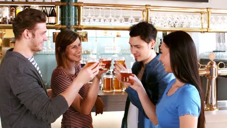 Happy-friends-toasting-a-glass-of-whisky-at-bar-counter