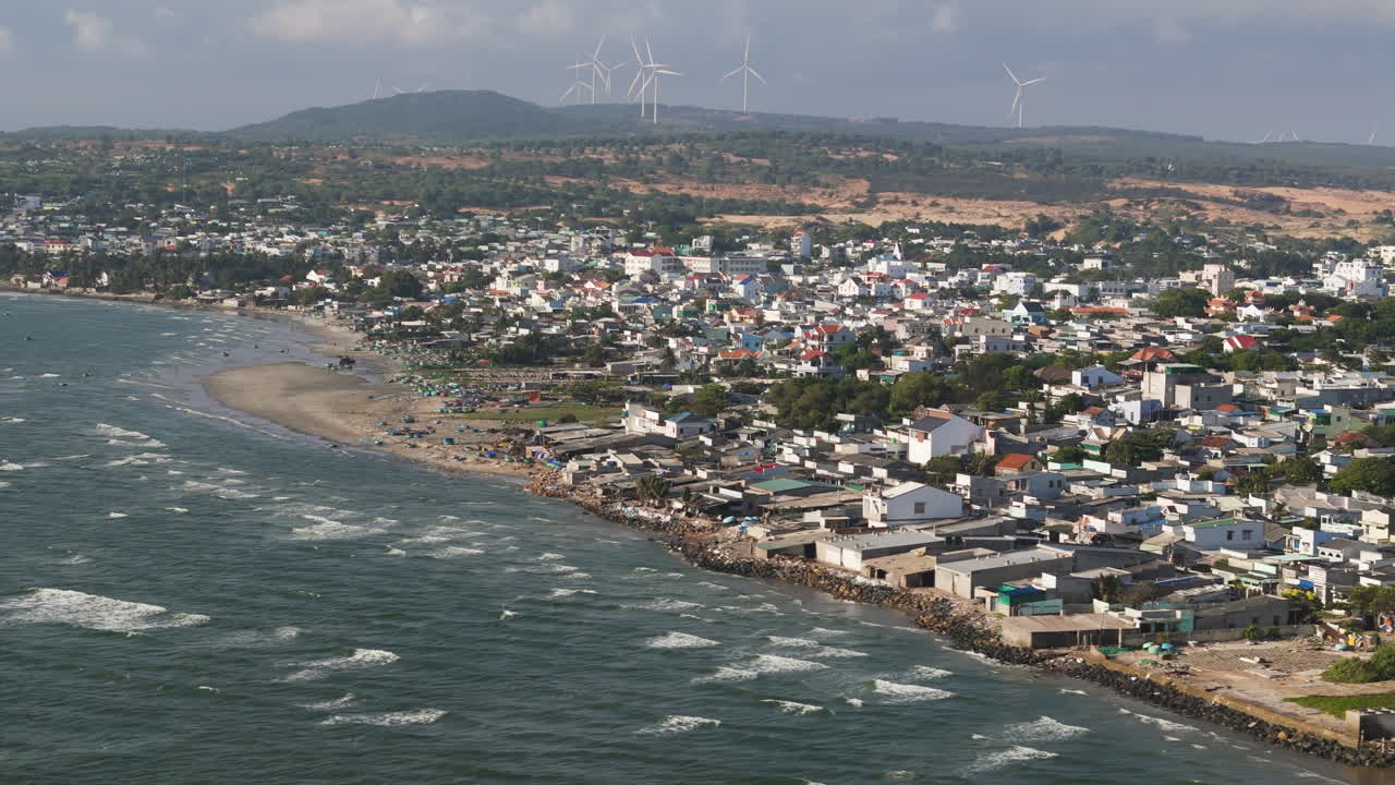 hermosa fotografía aérea de la aldea de pescadores thai mui ne con turbinas eólicas en el fondo