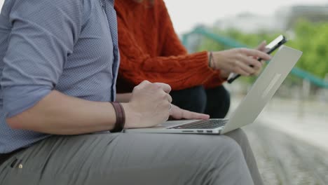 colegas que usan computadoras portátiles y tabletas al aire libre