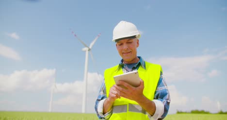 engineer using digital tablet on wind turbine farm 2