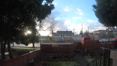static shot of traffic in the street outside the house on a bright sunny day