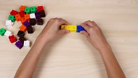 manos montando cubos de colores en una mesa