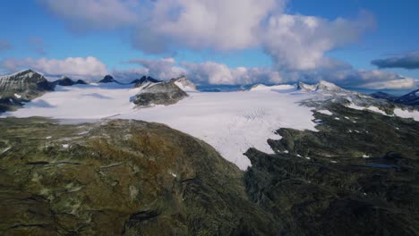 breathtaking aerial of glacier in norway. remote landscape with ice, clouds and rugged mountain scenery