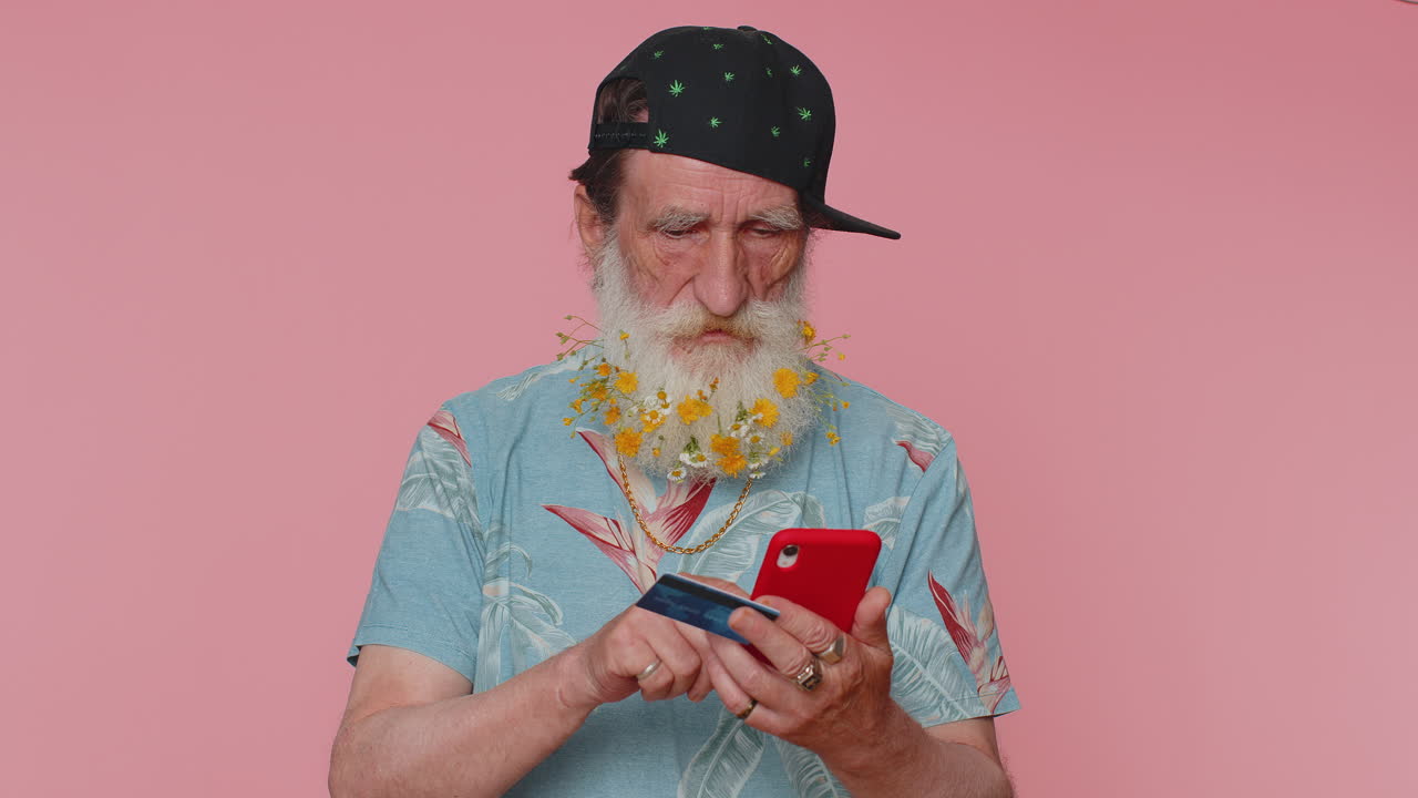 Senior man using credit bank card and smartphone while transferring money, purchases online shopping