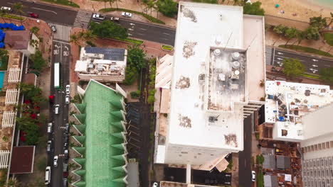 top down aerial shot flying over buildings and waikiki beach out to sea