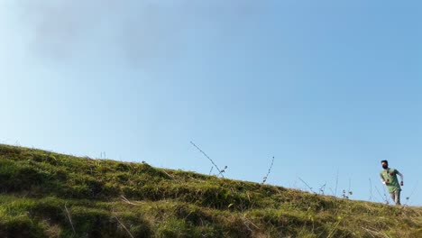 low angle of asian man with mask jogging uphill on hot day