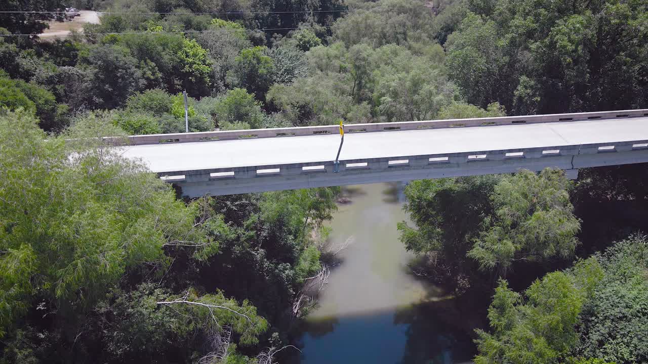 드론이 엘멘도르프의 작은 마을에 있는 산안토니오 강 위의 다리를 향해 날아갈 때 헛간 제비는 카메라 주위를 날아다닙니다.