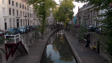 vista aérea del canal temprano en la mañana del nieuwe gracht en la ciudad holandesa medieval de utrecht pasando por una bicicleta bloqueada en el puente en primer plano que revela el muelle de nivel inferior