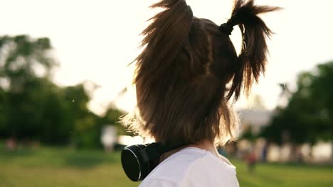 una chica con dos colas de caballo y gafas amarillas se divierte. posando para la cámara, divirtiéndose y riendo. auriculares negros