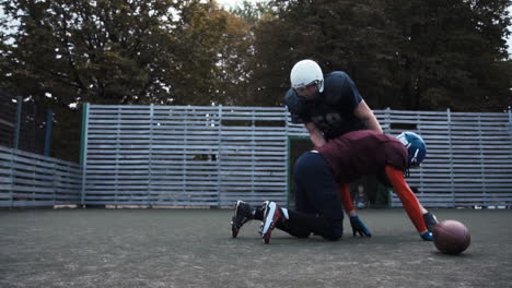 american football players training and tackling on a field