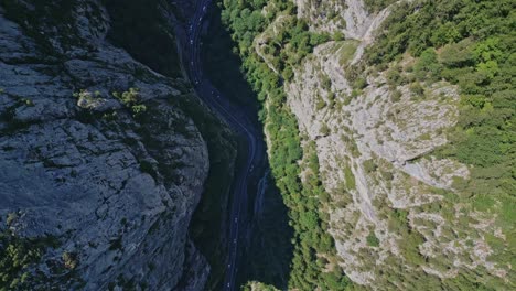 aerial top-down view of a winding road in a deep mountain canyon