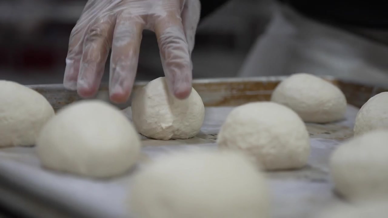 A woman preparing dough in a private bakery, captured in 4K resolution at 60fps, slow motion.