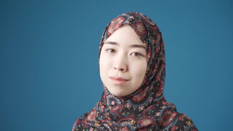 innocent and beautiful muslim asian woman in hijab smiling.