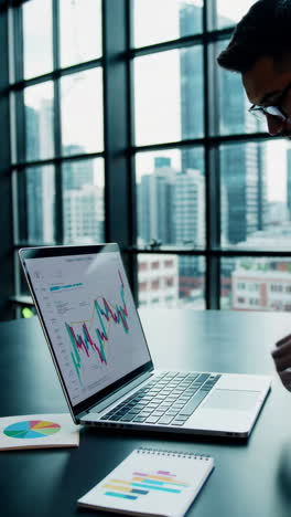 businessman analyzing financial data on laptop