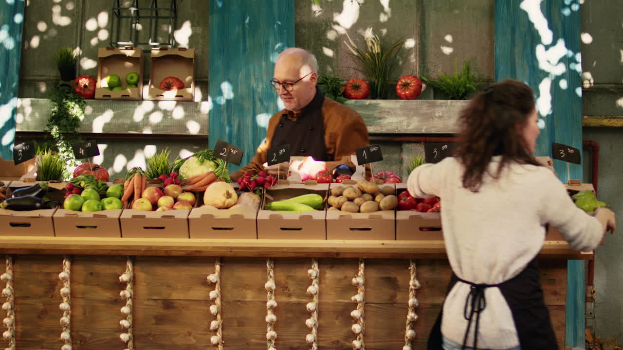 People buying and selling vegetables and fruit at a market stall